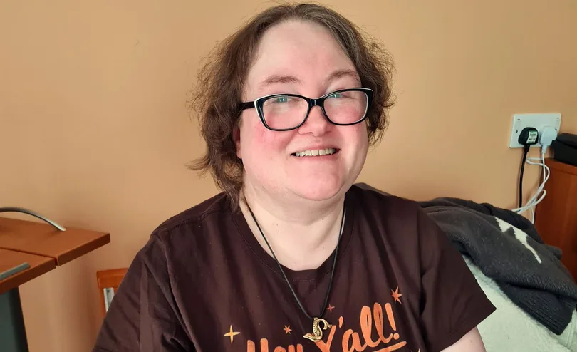 Mia smiling, seated indoors.