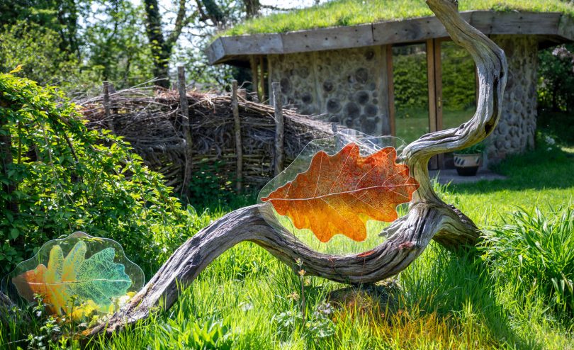 Stained glass panels featuring oak leaves in a hospice garden